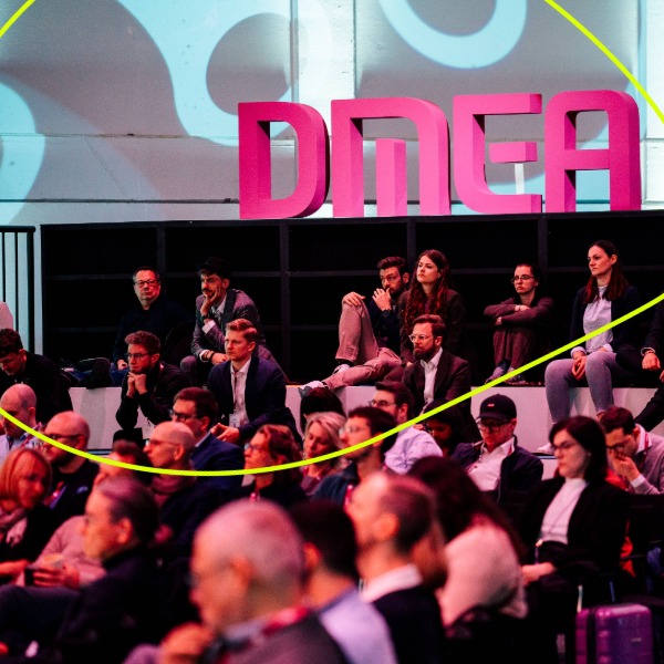 Personen sitzen im Publikum der DMEA Veranstaltung, man sieht große 3 D Buchstaben DMEA